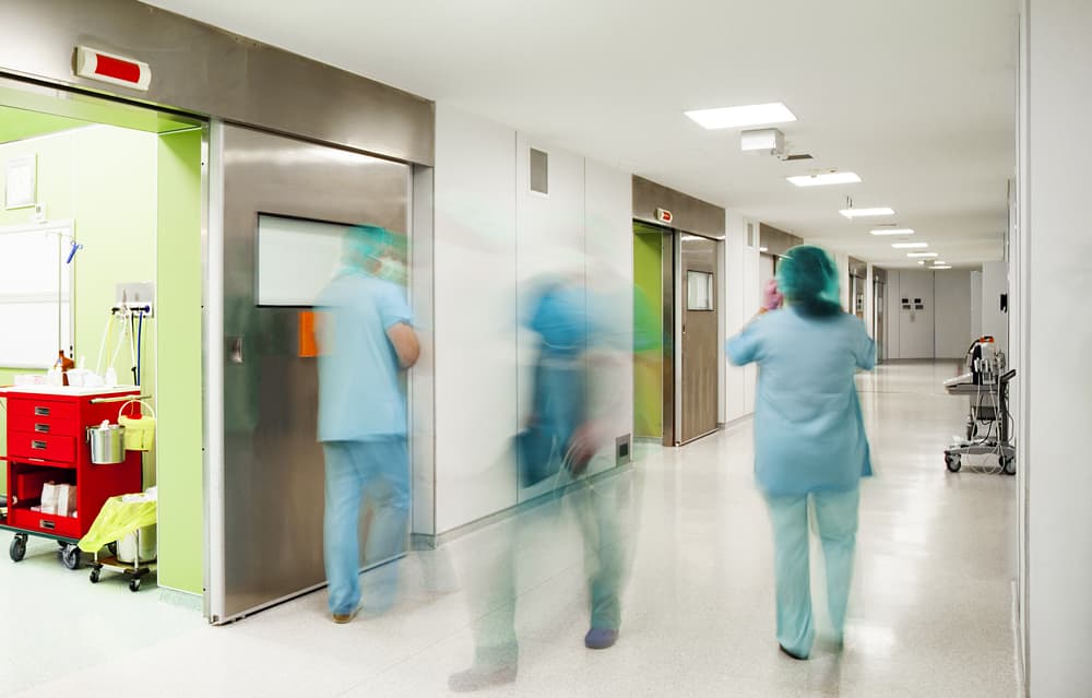 Blurry image depicting doctors preparing for surgery in a hospital operating room, highlighting medical procedures and healthcare professionals in action.