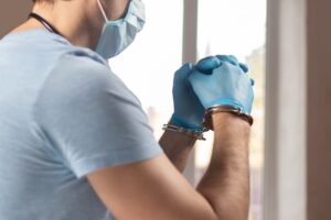 Doctor in handcuffs, symbolizing medical negligence.