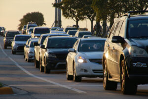 Cars in bumper-to-bumper traffic heading east on Palm Beach Lakes Blvd near Congress Ave in West Palm Beach at sunset.