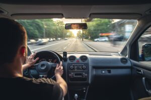 Hands gripping the wheel while driving at high speed, a reminder that speeding can easily lead to an accident.