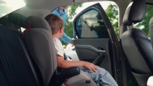 A child safely seated in a booster seat, adhering to Florida child car seat laws.