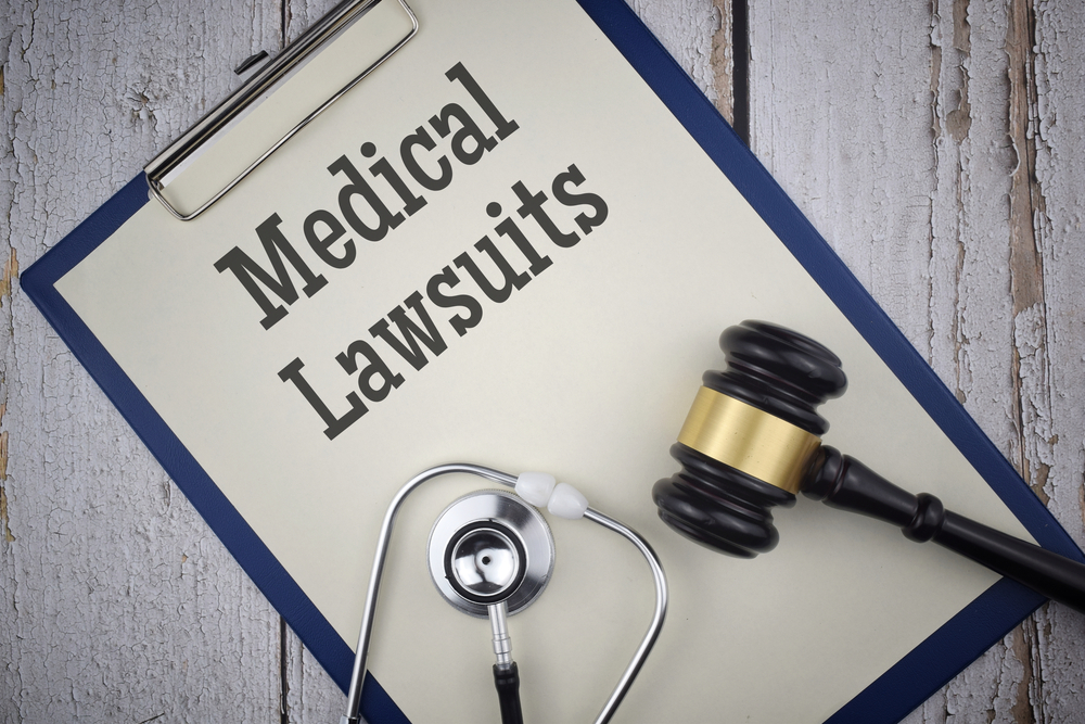 Medical Lawsuits wording with Gavel and stethoscope on a paper file. Medical and law concept